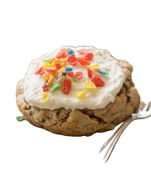 Cookie with whipped cream and colorful candies on a plate with a fork, jar of candies, and napkin on a wooden surface.
